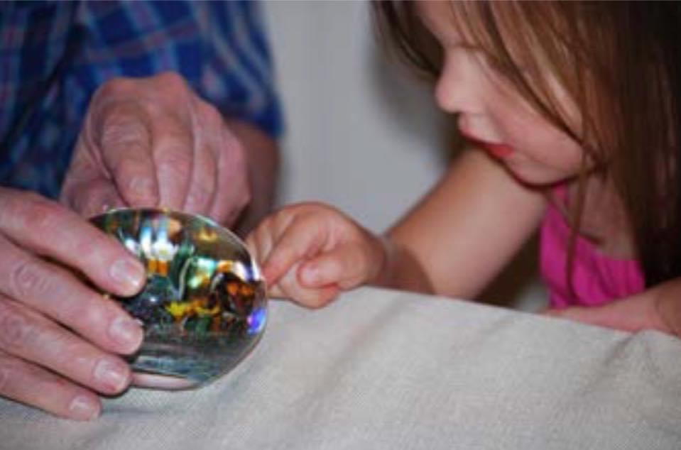 A child exploring a paperweight.